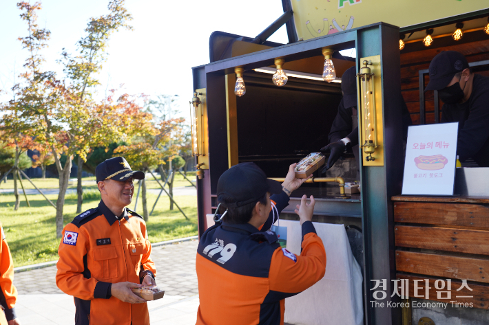 경북소방본부 소방관들이 한국원자력환경공단이 진행한 APEC 히어로 응원 캠페인을 통해 핫도그를 받고 있다. /사진=한국원자력환경공단