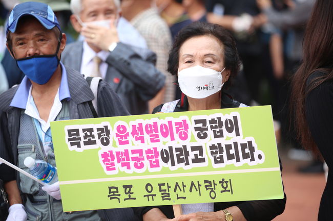 윤 전 총장의 지지자가 피켓을 들고 서있다.