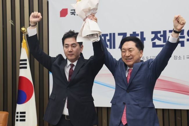 김가람 국민의힘 청년대변인이 9일 오후 서울 여의도 국회에서 열린 제7차 전국위원회에서 최고위원으로 선출된 후에 김기현 대표에게 꽃다발을 받고 함께 손을 들어올리고 있다.