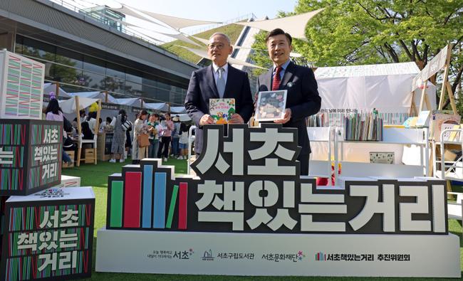 유인촌 문화체육관광부 장관이 12일 서울 서초구 국립중앙도서관 국제회의장에서 열린 도서관의 날 기념식에 참석하기에 앞서 서초책있는거리 홍보 부스에서 전성수 서초구청장과 기념촬영을 하고 있다.