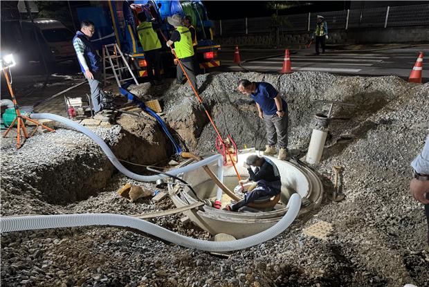 청주시, 오송2산단 상수관로 전 구간 세척완료_(청주시 직원들과 관계 업체 직원들이 오송2산단에서 세척기기를 상수관로로 투입해 야간작업을 진행하고 있는 모습)